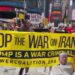 Demonstran membawa spanduk bertuliskan Stop the War on Iran Trump is a War Criminal di Amerika Serikat