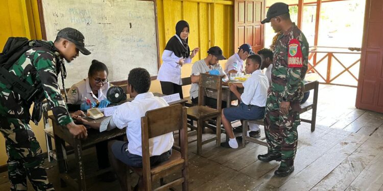 Babinsa Koramil 1710-06/Agimuga Dampingi Nakes Pada Kegiatan Pemeriksaan Kesehatan Kepada Pelajar