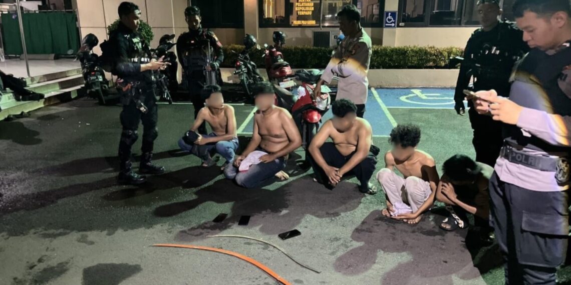 Personel Satuan Brimob Polda Metro Jaya mengamankan sejumlah senjata tajam dan barang bukti saat menggagalkan rencana tawuran dan balap liar di wilayah Jakarta Timur, Sabtu (17/1/2026) dini hari.