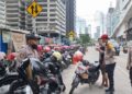 Personel Polsek Metro Setiabudi saat melakukan klarifikasi dan memberikan imbauan kepada juru parkir di kawasan Sudirman Tower, Jakarta Selatan. Penertiban dilakukan usai adanya laporan warga melalui layanan 110 terkait tarif parkir Rp10.000, Minggu (18/1/2026). (Foto: Dok. Humas Polri)