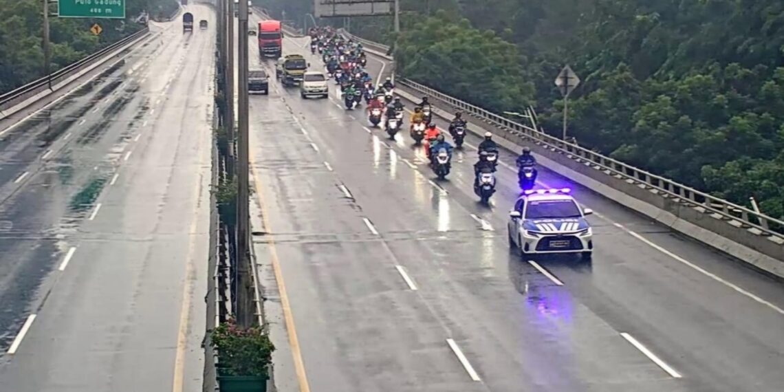 Pengendara sepeda motor melintas di Jalan Tol Wiyoto Wiyono setelah Ditlantas Polda Metro Jaya memberikan diskresi akibat banjir yang merendam Jalan Arteri Ahmad Yani, Jakarta, Minggu (18/1/2026).
