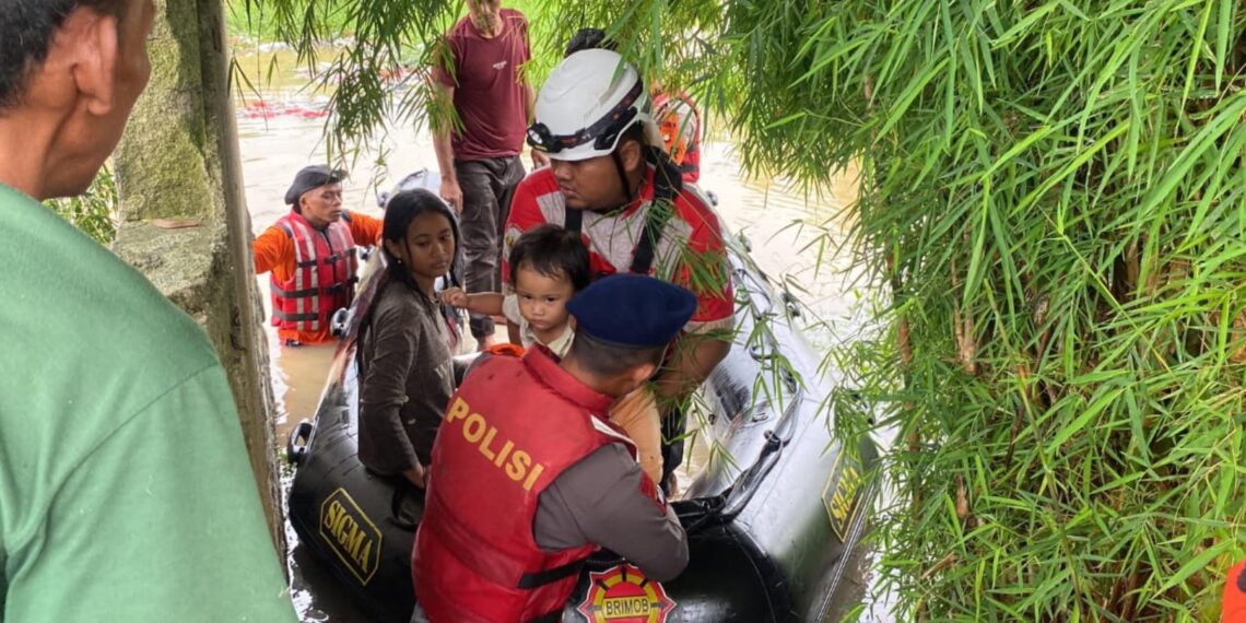 Personel Brimob Polda Metro Jaya mengevakuasi warga terdampak banjir di Kabupaten Bekasi, sekaligus mengamankan dokumen penting Minggu (18/1/2026).FOTO : IST