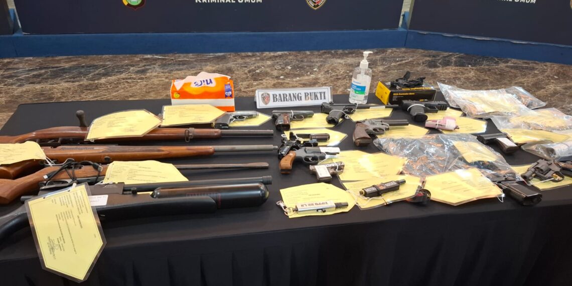 Barang Bukti Senpi Ilegal: Inilah deretan 20 pucuk senjata api rakitan dan airsoft gun yang berhasil disita Polda Metro Jaya dari tangan komplotan perakit asal Cipacing. Para pelaku memanfaatkan tutorial di YouTube untuk menciptakan senjata berbahaya dan menjualnya secara bebas di marketplace. (Foto: Ekoin.co, AMSI).