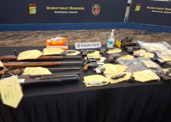 Barang Bukti Senpi Ilegal: Inilah deretan 20 pucuk senjata api rakitan dan airsoft gun yang berhasil disita Polda Metro Jaya dari tangan komplotan perakit asal Cipacing. Para pelaku memanfaatkan tutorial di YouTube untuk menciptakan senjata berbahaya dan menjualnya secara bebas di marketplace. (Foto: Ekoin.co, AMSI).