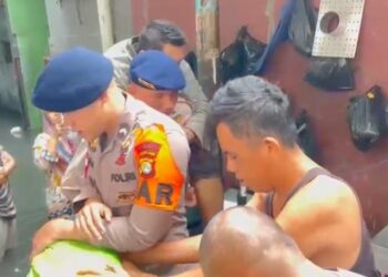 Personel SAR Brimob Polda Metro Jaya saat mengevakuasi warga yang sedang sakit di tengah kepungan banjir Jakarta Barat, Kamis (29/1/2026). Selain evakuasi, Polri menyiagakan layanan darurat 110 untuk merespons kebutuhan masyarakat di lokasi bencana. (Foto: Dok. Humas Polda Metro Jaya/Ekoin.co)