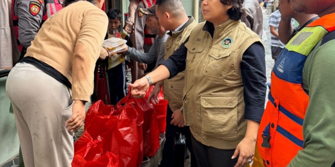 Personel Sat Samapta Polres Metro Bekasi Kota menyalurkan nasi siap saji kepada warga terdampak banjir di Kampung Lebak, Kelurahan Teluk Pucung, Bekasi Utara, Jumat (30/1/2026).