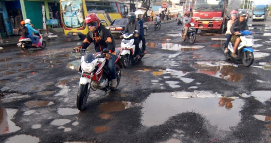 Kondisi jalan berlubang di Jakarta yang tertutup genangan air berpotensi meningkatkan risiko kecelakaan lalu lintas saat musim hujan.