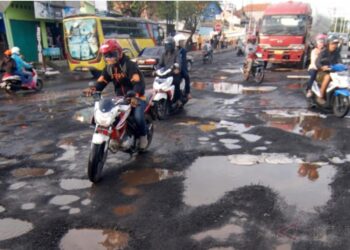 Kondisi jalan berlubang di Jakarta yang tertutup genangan air berpotensi meningkatkan risiko kecelakaan lalu lintas saat musim hujan.