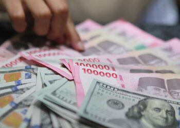 Pekerja menghitung uang rupiah di tempat penukaran mata uang asing di Jakarta, Senin (19/1/2026)