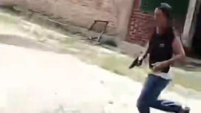 Tangkapan layar video viral yang menunjukkan seorang oknum Kepala Desa tengah mengacungkan senjata ke arah warga di tengah sengketa lahan sawit. Pihak kepolisian diminta segera mengusut legalitas senjata dan tindakan intimidasi tersebut. (Foto: Ekoin.co/Istimewa)