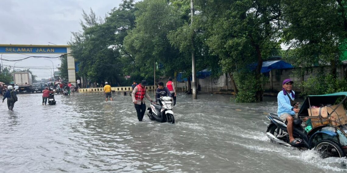 Polisi Polda Metro Jaya sedang siaga dan membantu warga terdampak genangan air rob di Pelabuhan Perikanan Muara Baru, Jakarta Utara, Minggu (1/2/2026).
