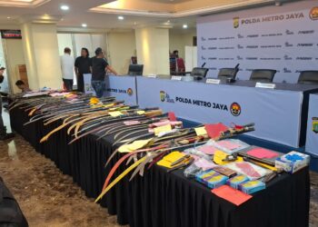 Dirsamapta Polda Metro Jaya Kombes Wahyu Dwi Ariwibowo bersama Kabid Humas Kombes Budi Hermanto menunjukkan barisan senjata tajam dan ribuan botol miras hasil sitaan Operasi Pekat Jaya 2026, Kamis (12/2/2026).