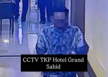 Pelaku berinisial NW (43) saat diamankan petugas beserta barang bukti baju batik dan lanyard yang digunakan untuk mengelabui korban di area hotel mewah. (Foto: Dok. Humas Polda Metro Jaya/Istimewa)