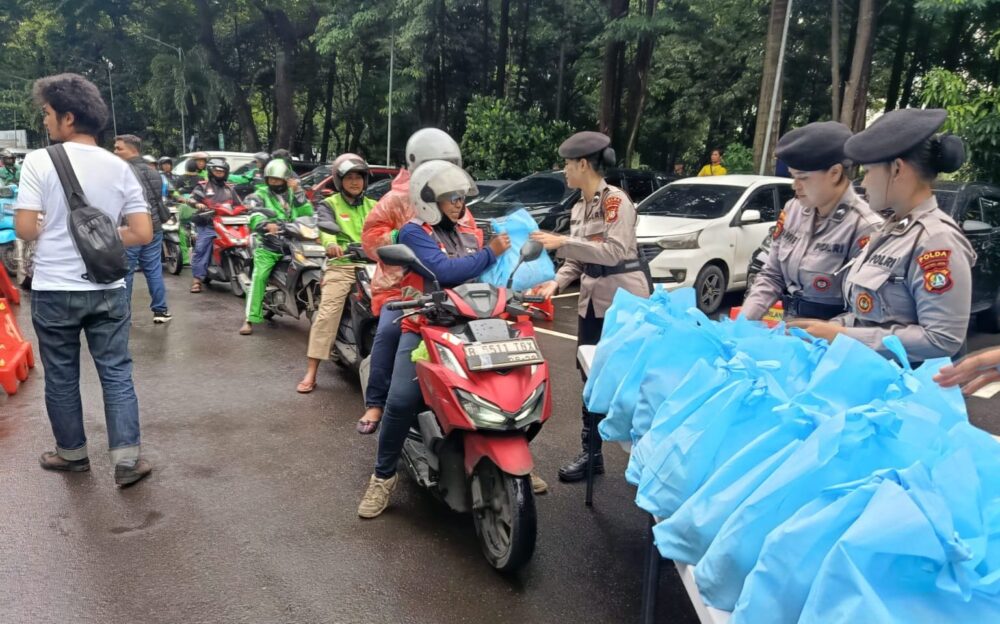 Personel Polda Metro Jaya menyalurkan paket sembako kepada pengemudi ojek online dan Pegawai Harian Lepas dalam kegiatan sosial Jumat Peduli di wilayah Jabodetabek, Jumat (6/3/2026).