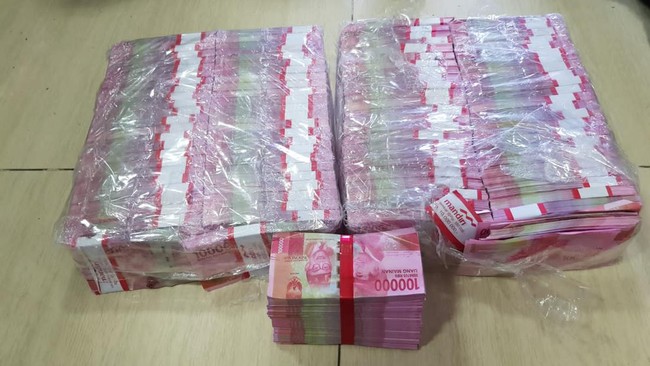 Polisi menunjukkan barang bukti uang palsu dan perlengkapan ritual yang digunakan pelaku penipuan bermodus penggandaan uang di Pancoran Mas, Kota Depok.