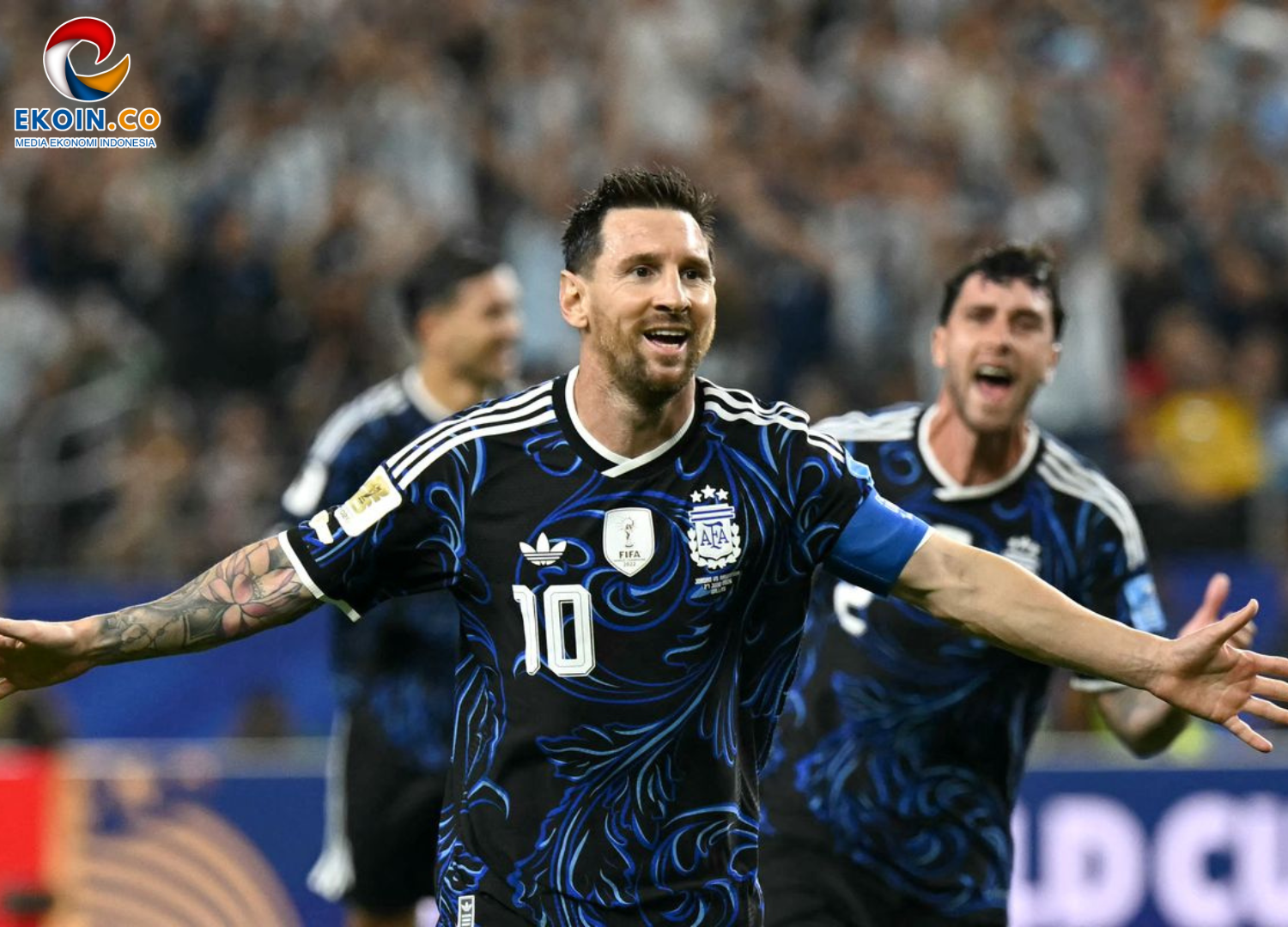Argentine footballer wearing number 10 in a blue-black kit, arms outstretched in celebration on the field with a cheering crowd behind him