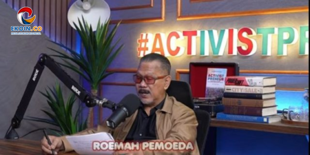 Man with red-tinted glasses speaks into a studio microphone; overlay text reads 'ROEMAH PEMOEDA' as books and a plant sit behind him, with an EKOIN.CO logo in the corner.