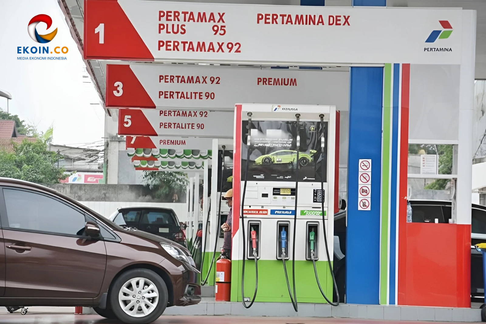 Gas station pump island with red and white signage listing Pertamax Plus 95 and Pertamax 92; a brown car is in the foreground to the left.