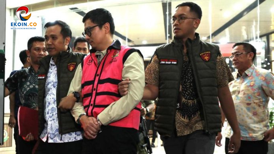 Group of men escorting a handcuffed man in a pink jacket through a public area; security personnel flank him. Inset: EKO IN logo on top-left.