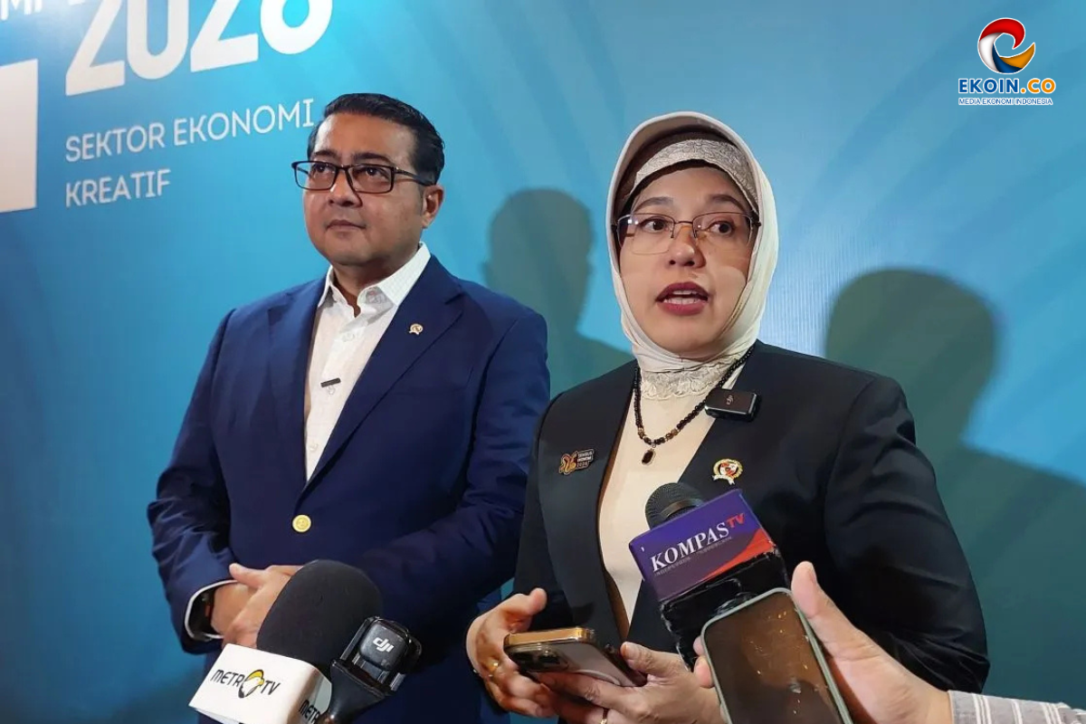 Two professionals in formal attire speak to reporters at a media event; microphones from Kompas TV and Metro TV in front of a blue backdrop.