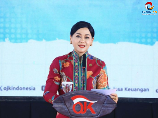 Indonesian woman in a colorful batik outfit speaks at a podium with a red OK logo on stage.