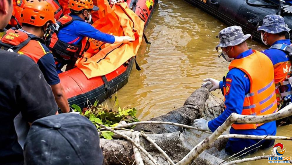 Rescue workers in orange life jackets and blue uniforms pull a large log from a muddy river during a rescue operation near a boat.